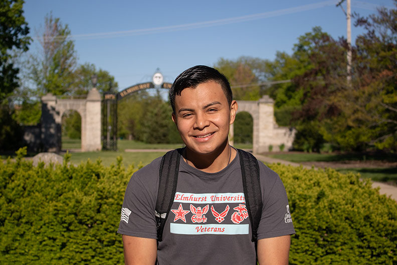 A male military veteran student on the campus of Elmhurst University.