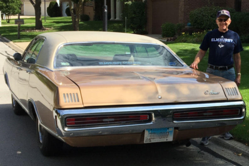 Elmhurst University alumnus Keith Reed stands next to the 1970 Dodge Monaco he used to commute to school every day as a student.