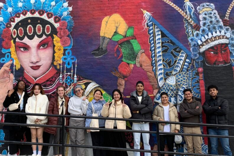 Elmhurst University students in front of a mural in Chinatown.