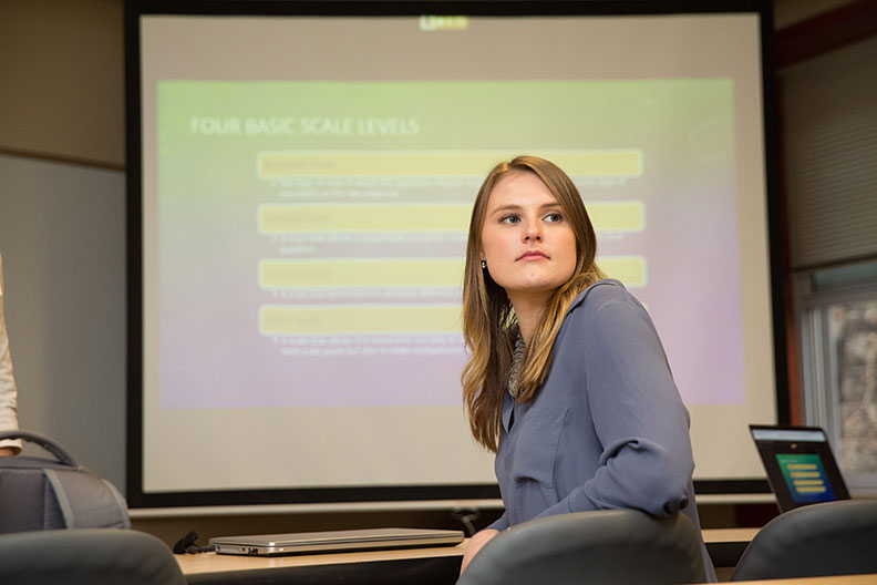 A student in academic centers turns around in her chair during a graduate marketing research class at Elmhurst College.