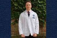 Photo of Elmhurst College student Nicholas Bank getting his white coat at Case Western Reserve University School of Medicine.