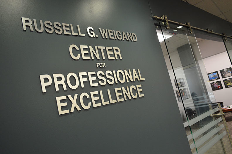 The words "Russell G. Weigand Center for Professional Excellence" are shown outside the office space in academic centers that houses Elmhurst College's career center.